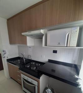 uma cozinha com um fogão e um micro-ondas em Apartamento inteiro com garagem coberta Treviso em União da Vitória