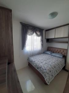 um quarto com uma cama e uma janela em Apartamento inteiro com garagem coberta Treviso em União da Vitória