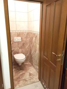 a bathroom with a toilet and a door at Apartments Captain Grand Prague in Prague