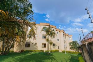 un edificio con una palmera delante en KAMI LUXURY APARTMENTS, en Kigali
