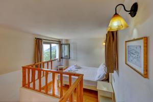 a bedroom with a bed and a staircase with a window at Mourtzanakis Residence - Traditional Eco Hotel in Achlada in Achlada