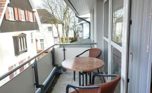 a small balcony with a wooden table and chairs at Villa Maria by Rujana in Binz
