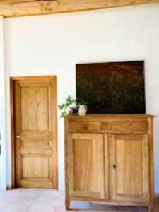 um armário de madeira com uma televisão de ecrã plano ao lado de uma porta em Maison à Aix en provence au pied de la Sainte Victoire em Beaurecueil