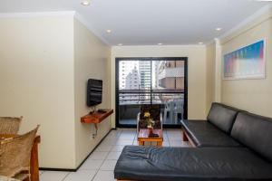 a living room with a black couch and a window at ApartmentFortaleza Porto de Iracema in Fortaleza