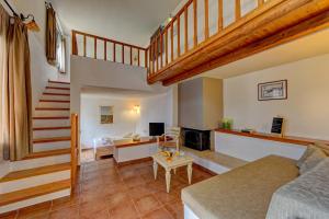 a living room with a staircase and a couch at Mourtzanakis Residence - Traditional Eco Hotel in Achlada in Achlada