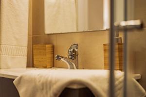 a bathroom sink with a faucet and a mirror at Breathe In in Zambujeira do Mar