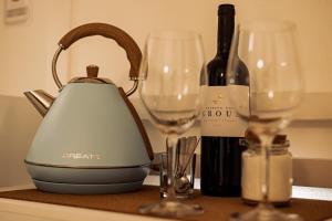 a tea kettle and two wine glasses on a counter at Breathe In in Zambujeira do Mar