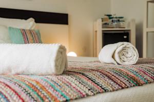 a pile of towels sitting on top of a bed at Breathe In in Zambujeira do Mar