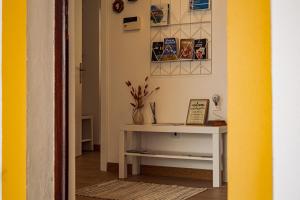 a hallway with a white table and some pictures on the wall at Breathe In in Zambujeira do Mar