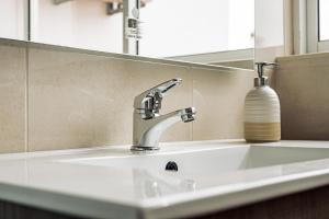 a sink in a bathroom with a mirror and a soap dispenser at Breathe In in Zambujeira do Mar