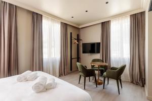 um quarto de hotel com uma cama, uma mesa e cadeiras em Gogaille - Corneille - Accès autonome em Tours