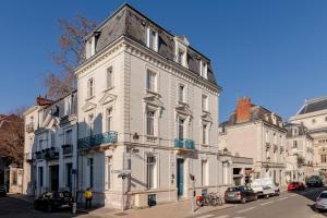 un gran edificio blanco en una calle de la ciudad en Gogaille - Corneille - Accès autonome en Tours