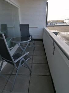 einen Tisch und Stühle auf einem Balkon mit Fenster in der Unterkunft SPO - gemütliches Apartment - TOP LAGE in Sankt Peter-Ording