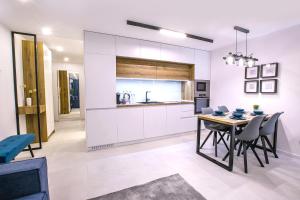 una cucina e una sala da pranzo con tavolo e sedie di South Place Apartments a Sandanski