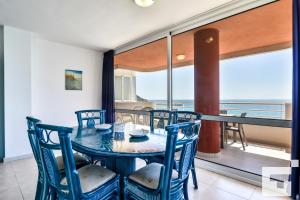 comedor con mesa y sillas y balcón en Apartamento Rubino 5C - Grupo Turis, en Calpe
