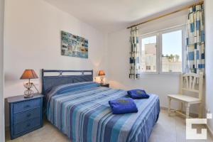 sypialnia z łóżkiem z niebieskimi poduszkami w obiekcie Apartamento Rubino 5C - Grupo Turis w mieście Calpe