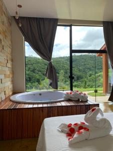a room with a large tub with a large window at Chacara Belo Encanto in Santo Antônio do Pinhal +11 photos