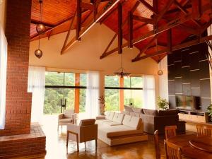 a living room with a white couch and some windows at Chacara Belo Encanto in Santo Antônio do Pinhal