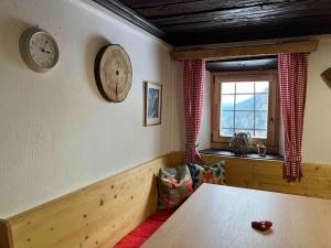 una habitación con una mesa y un reloj en la pared en Berghütte Hochhalt, en Unteralpe