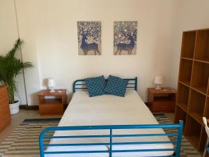 a bedroom with a bed with two paintings on the wall at Udine Urban Stay in Udine