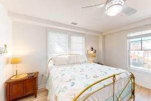 1 dormitorio con 1 cama y 2 ventanas en The Sanctuary - A Wave from it All 201B en Virginia Beach