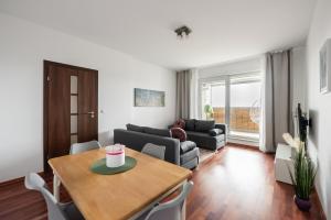 een woonkamer met een tafel en een bank bij Okopowa Joyful Apartment in Warschau