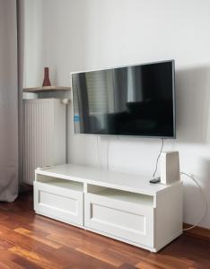 een wit entertainmentcentrum met een flatscreen-tv bij Okopowa Joyful Apartment in Warschau