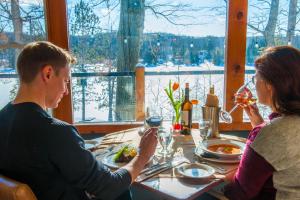two women and a man sitting at a table with wine glasses at Heather Lodge in Minden