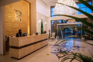a woman sitting at a desk in a lobby at فندق بلفيو بارك الخمسين-Bellevue Park Hotel in Taif