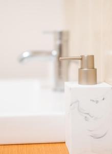 a bathroom with a sink and a faucet at D'City Apartment, up to 6 guests in Dundee