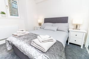 Un dormitorio con dos camas con toallas encima. en D'City Apartment, up to 5 guests, en Dundee