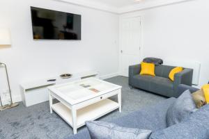 ein Wohnzimmer mit einem Sofa und einem Couchtisch in der Unterkunft D'City Apartment, up to 6 guests in Dundee
