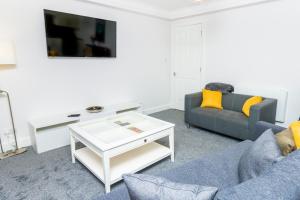 Una sala de estar con un sofá y una mesa de café. en D'City Apartment, up to 5 guests, en Dundee