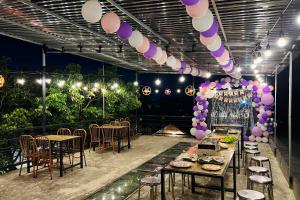 a party with tables and chairs and purple and white balloons at Lacasa home&coffee Mộc Châu in Mộc Châu