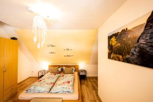 um quarto com uma cama e um quadro na parede em Waldblickwohnung für bis zu 5P mit Kamin und Sauna em Sebnitz