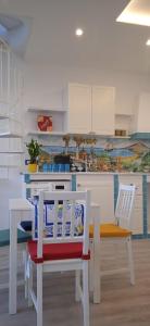 a kitchen with a table and two chairs and a table and a kitchen at Donna Sicilia 2 in Giardini Naxos