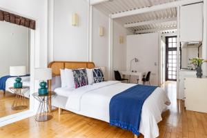 a white bedroom with a bed and a desk at BLUE PERA HOUSE in Istanbul