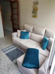 a living room with a white couch with blue pillows at Mar de Prata in Maia