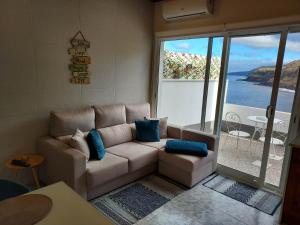 a living room with a couch and a view of the ocean at Mar de Prata in Maia