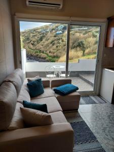 a living room with a couch and a large window at Mar de Prata in Maia