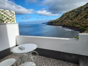 a table and chairs on a balcony with a view of the ocean at Mar de Prata in Maia