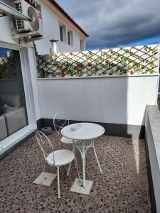 a white table and two chairs on a balcony at Mar de Prata in Maia