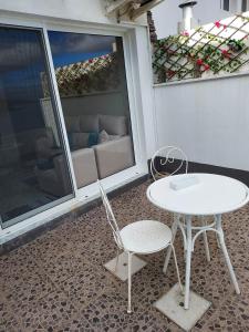a white table and two chairs on a patio at Mar de Prata in Maia