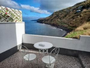 a balcony with a table and two chairs and the ocean at Mar de Prata in Maia
