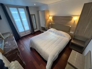 パリにあるホテル セルティックのベッドルーム1室(白いベッド1台付)