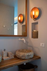 a bathroom with a stone sink and a mirror at Amethyst Selene Paleros Couple's Hideaway in Paleros