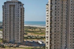 two tall buildings standing next to each other at Стильные апартаменты Dotan in Netanya