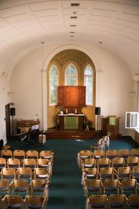 an empty room with chairs and a stage in it at Gäste- und Tagungshaus am Glockengarten in Berlin