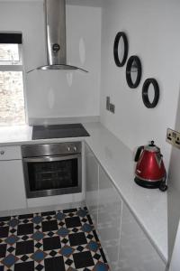 Seaside 3 Bed Killybegs Property on Main Street في كليبيغز: مطبخ مع موقد وغلاية شاي