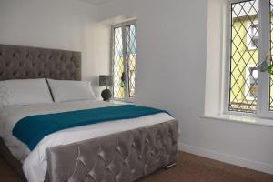 a bedroom with a large bed and two windows at Seaside 3 Bed Killybegs Property on Main Street in Killybegs